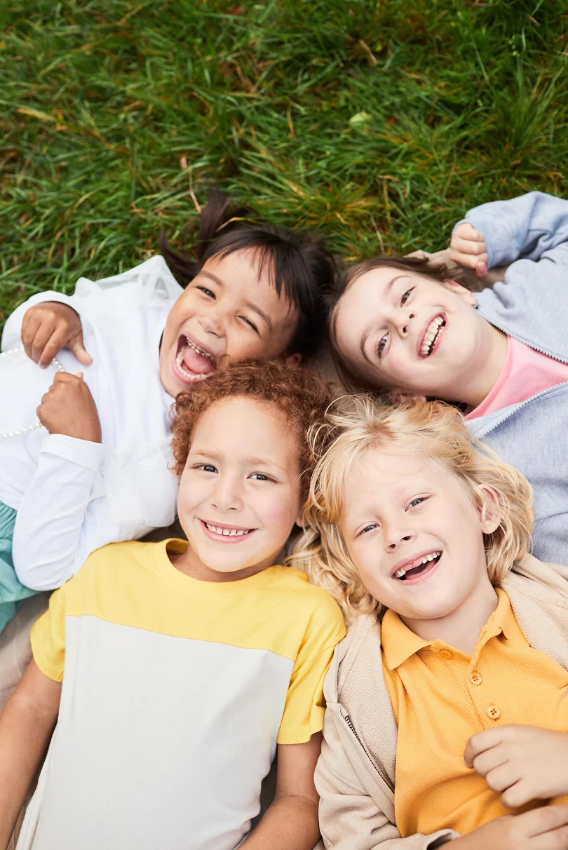 smiling children lying on grass